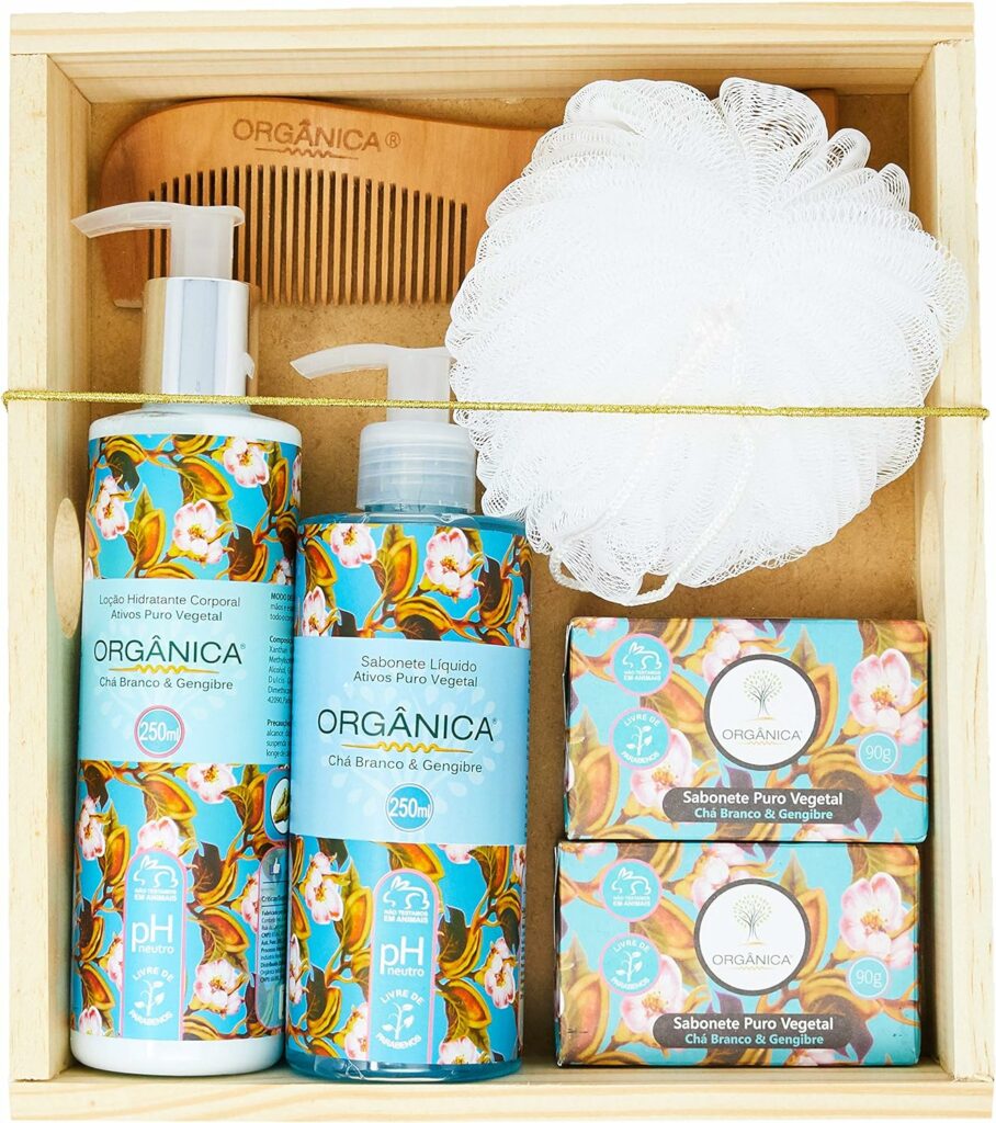 Kit de banho com Loção hidratante, sabonete líquido, dois sabonetes em barra, uma esponja e um pente de madeira. Os produtos estão guardados em uma caixa de madeira e as embalagens são na cor azul, com fragrância de chá brando e gengibre